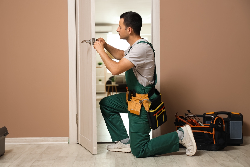 Male,worker,with,screwdriver,repairing,door,at,home
